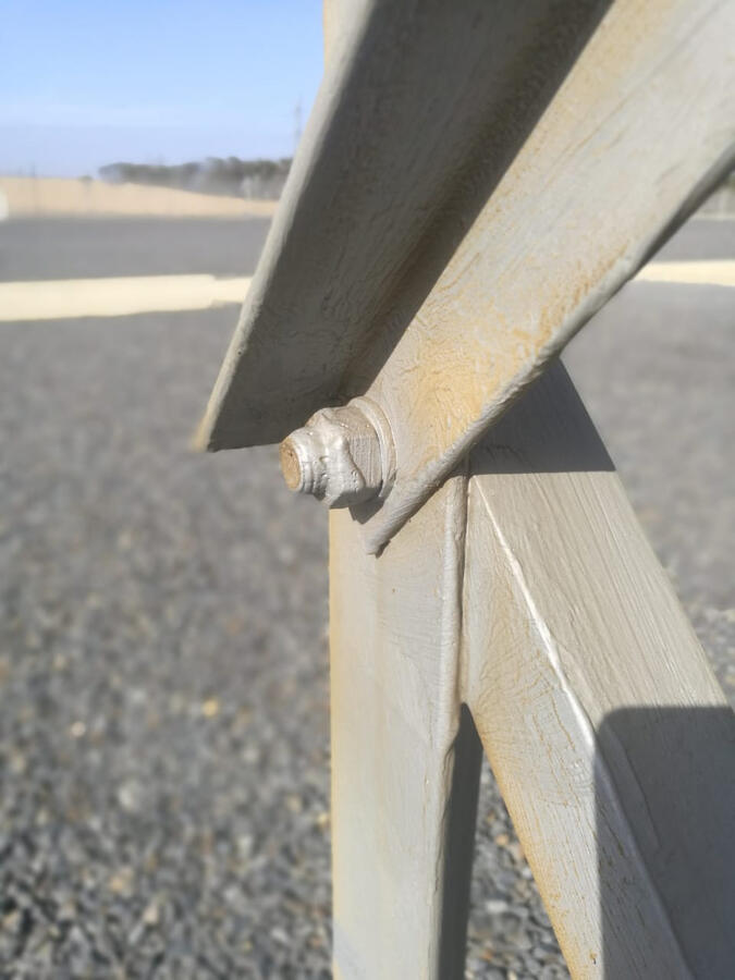 Close-up of a bolted connection between steel braces in a substation structure.