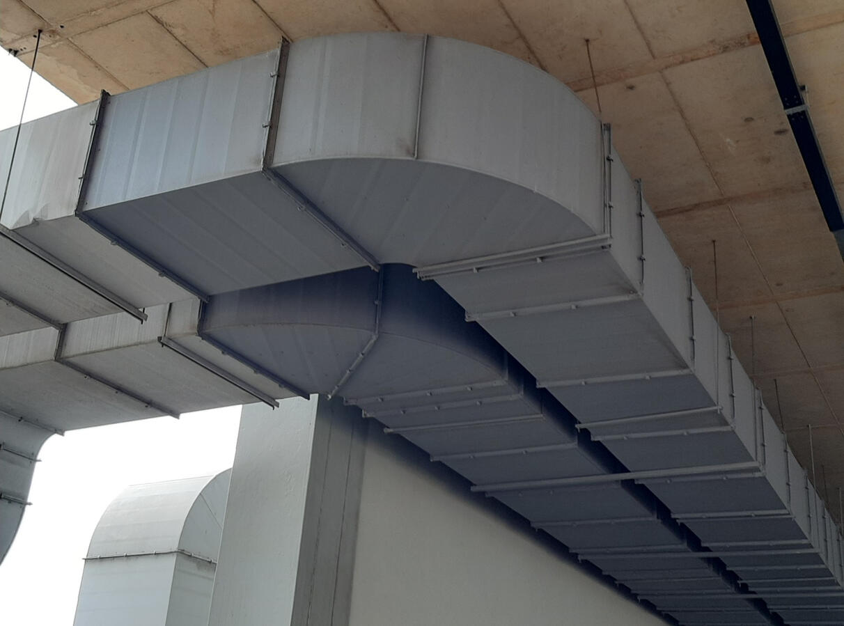 Rectangular ventilation ductwork suspended beneath a concrete ceiling.